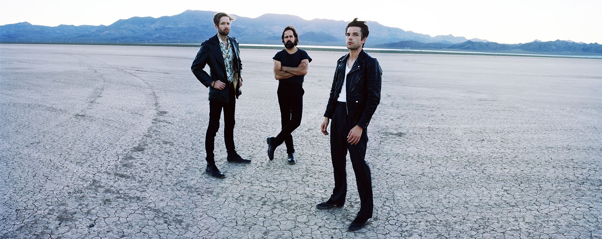 Portrait of The Killers band members standing up in the desert - credits The Killers - Estereo Picnic 2026 - Lineupping.com